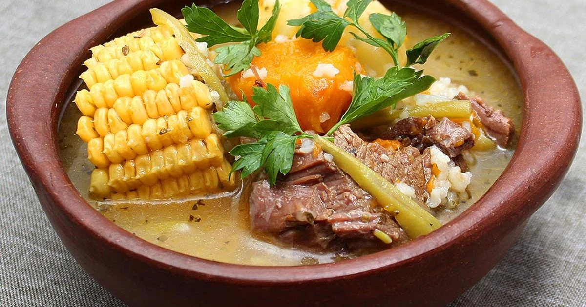 Cazuela de vacuno en fuente de greda, con choclo, zapallo y perejil